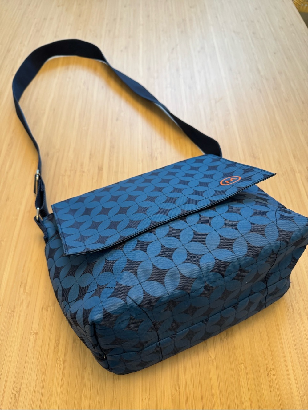 Cosmoda Corp blue geometric small  messenger lunch bag with orange “M” logo